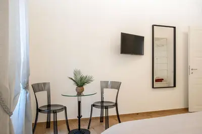 a room with a table and two chairs and a mirror at Margherita Flat in Rome