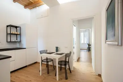 a white kitchen with a table and chairs at Margherita Flat in Rome