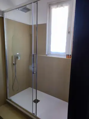 a shower with a glass door and a window at Appartamento Lavatore in Rome