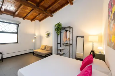 a bedroom with a white bed and a couch at Loft Ostiense Green in Rome