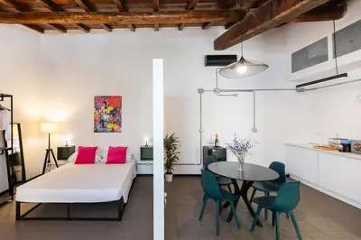 a bedroom and a living room with a bed and a table at Loft Ostiense Green in Rome