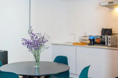 a table with a vase of purple flowers on it at Loft Ostiense Green in Rome