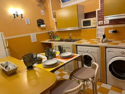 a kitchen with a table and a washing machine at Aventino The Yellow Home in Rome