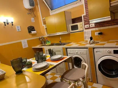 a kitchen with a sink and a washing machine at Aventino The Yellow Home in Rome