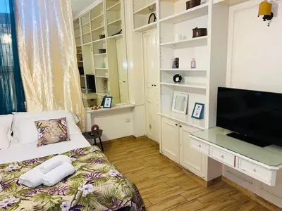 a bedroom with a bed with a desk and a television at Aventino The Yellow Home in Rome