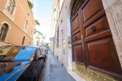 a car parked next to a building with a large wooden door at Gian's Trevi BuddyRent in Rome