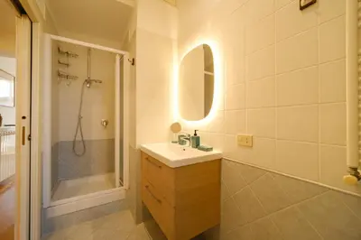 a bathroom with a sink and a shower and a mirror at Gian's Trevi BuddyRent in Rome