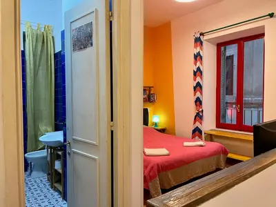 a small room with a bed and a window at Trastevere Hideaway in Rome