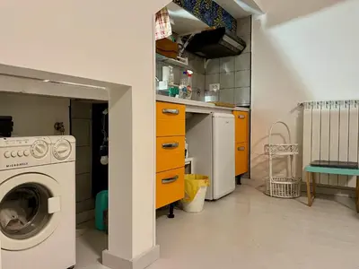 a kitchen with a washing machine and yellow cabinets at Trastevere Hideaway in Rome