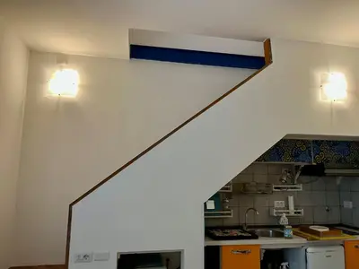 a kitchen with two lights on the wall and a staircase at Trastevere Hideaway in Rome