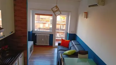 a living room with a blue couch and a window at White Sun in Rome