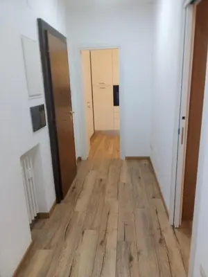 a hallway of an apartment with a wooden floor at White Sun in Rome