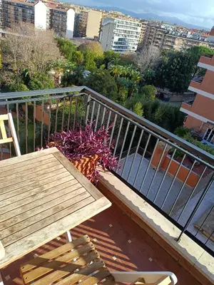 a balcony with a wooden bench and a table and flowers at White Sun in Rome