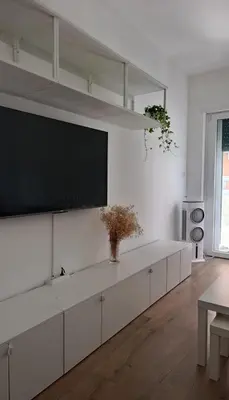 a white living room with a flat screen tv on a wall at Rome Tiburtina Terrace Inn - casa vacanze in Rome