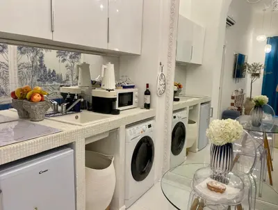 a kitchen with washing machines and a counter with a sink at Midorigami Jacuzzi suite Spanish Steps apt in Rome