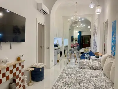 a living room with a couch and a tv on a wall at Midorigami Jacuzzi suite Spanish Steps apt in Rome