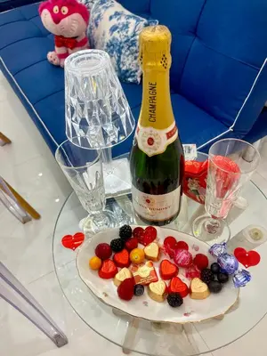 a glass table with a bottle of wine and a plate of fruit at Midorigami Jacuzzi suite Spanish Steps apt in Rome
