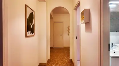 a hallway with an archway and a white door at Vatican St Peter Apartment in Rome