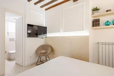 a bedroom with white cabinets and a chair at Boutique Apartment Steps from Colosseum in Rome