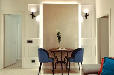 a table with chairs and a vase with flowers on it at Boutique Apartment Steps from Colosseum in Rome