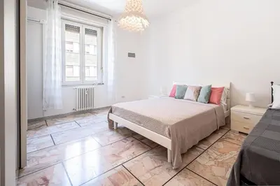 a white bedroom with a bed and a large window at Rome Sweet Home I Elegance and Authenticity in Rome