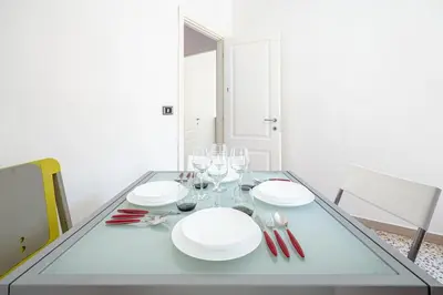 a dining table with white plates and wine glasses at Rome Sweet Home I Elegance and Authenticity in Rome