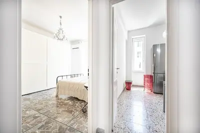 a white room with a bed and a refrigerator at Rome Sweet Home I Elegance and Authenticity in Rome