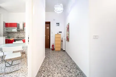 a kitchen with white walls and a hallway with a table and chairs at Rome Sweet Home I Elegance and Authenticity in Rome