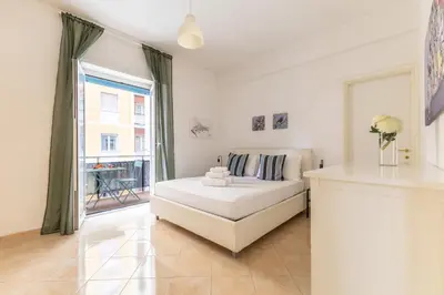 a bedroom with a bed and a large window at Hostly Forlanini Family Apartment near Gianicolo in Rome