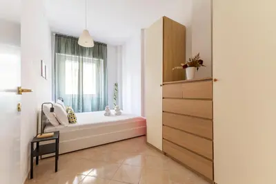 a bathroom with a bath tub and a window at Hostly Forlanini Family Apartment near Gianicolo in Rome