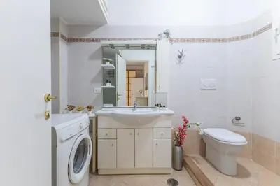 a bathroom with a sink and a washing machine at Hostly Forlanini Family Apartment near Gianicolo in Rome