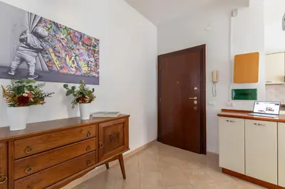 a kitchen with a wooden dresser and a painting on the wall at Hostly Forlanini Family Apartment near Gianicolo in Rome