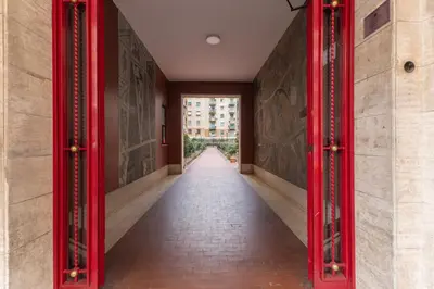 a hallway with red columns in a building at Hostly Forlanini Family Apartment near Gianicolo in Rome
