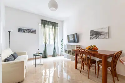 a living room with a wooden table and chairs at Hostly Forlanini Family Apartment near Gianicolo in Rome
