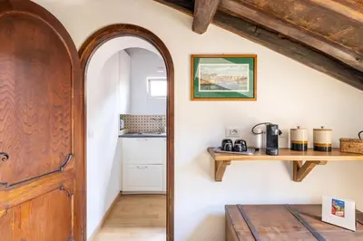 a hallway with a wooden door and a kitchen at Attico con terrazza privata silenzioso casa Mem in Rome