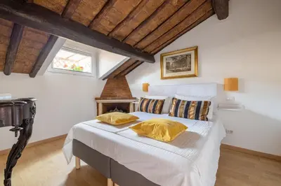 a bedroom with a bed with yellow pillows on it at Attico con terrazza privata silenzioso casa Mem in Rome