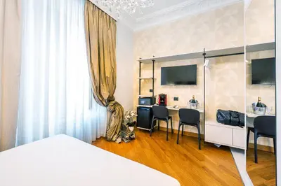 a bedroom with a bed and a table and chairs at Gracchi Vatican View in Rome