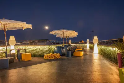 a rooftop patio with chairs and umbrellas at night at Gracchi Vatican View in Rome