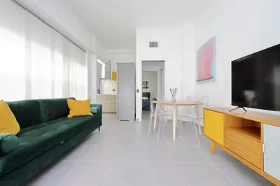 a living room with a green couch and a television at La Dolce Vita - Your perfect base to explore Rome in Rome