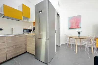 a stainless steel refrigerator in a kitchen with a table at La Dolce Vita - Your perfect base to explore Rome in Rome