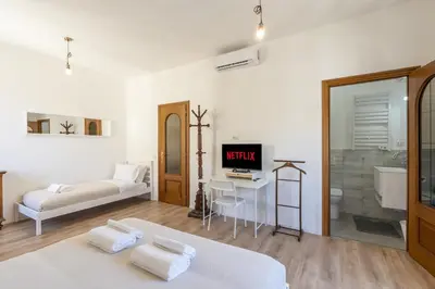 a living room with a bed and a tv and a tub at Guest House Rome - Pigneto in Rome