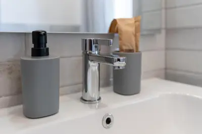 a bathroom sink with a faucet and two trash cans at Guest House Rome - Pigneto in Rome