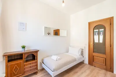 a small bedroom with a bed and a wooden cabinet at Guest House Rome - Pigneto in Rome