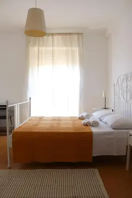 a bedroom with a large bed with a large window at Dimora Trasteverina Holiday Home in Rome