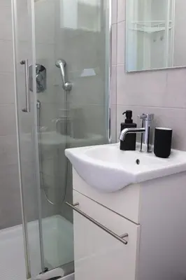 a white bathroom with a sink and a shower at Dimora Trasteverina Holiday Home in Rome