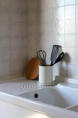 a container of utensils sitting on top of a sink at Dimora Trasteverina Holiday Home in Rome