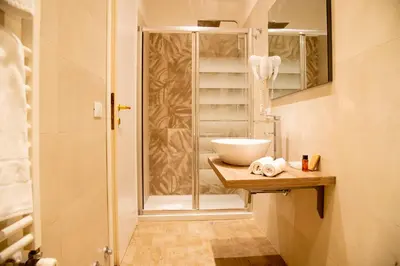 a bathroom with a glass shower and a sink at Domus Napoleone in Rome