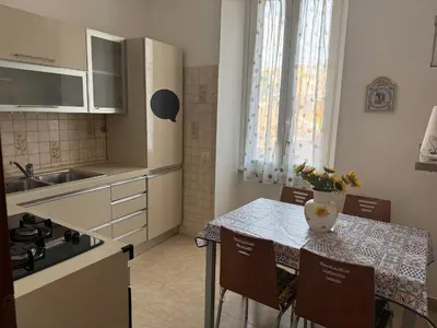 a kitchen with a table with a vase of flowers on it at DolceCasa - Re di Roma Apartment in Rome