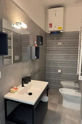 a bathroom with a white sink and a toilet at DolceCasa - Re di Roma Apartment in Rome