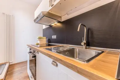 a kitchen with a stainless steel sink and black wall at APT ROME Fratte di Trastevere in Rome